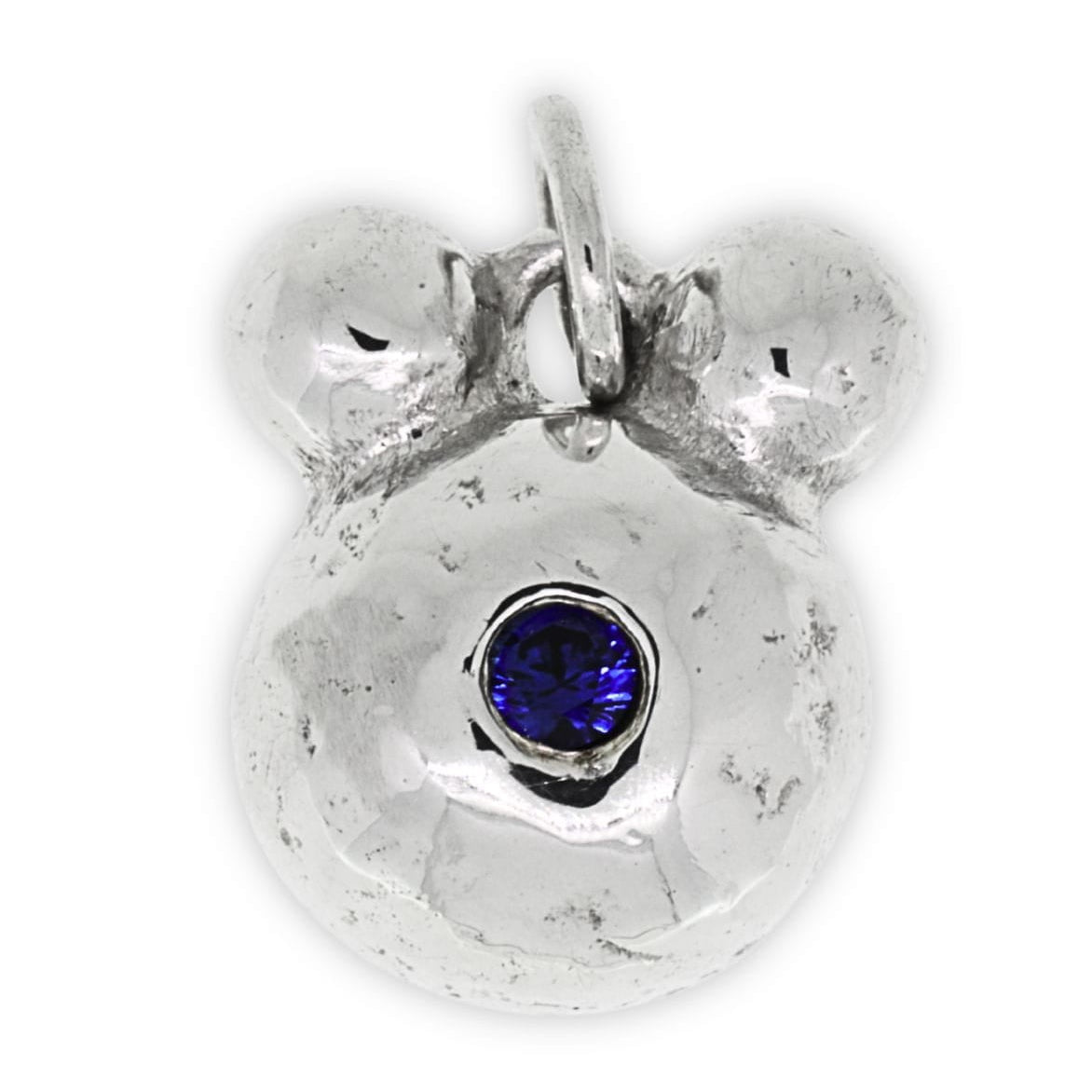 Silver bear pendant with a blue gemstone on a white background