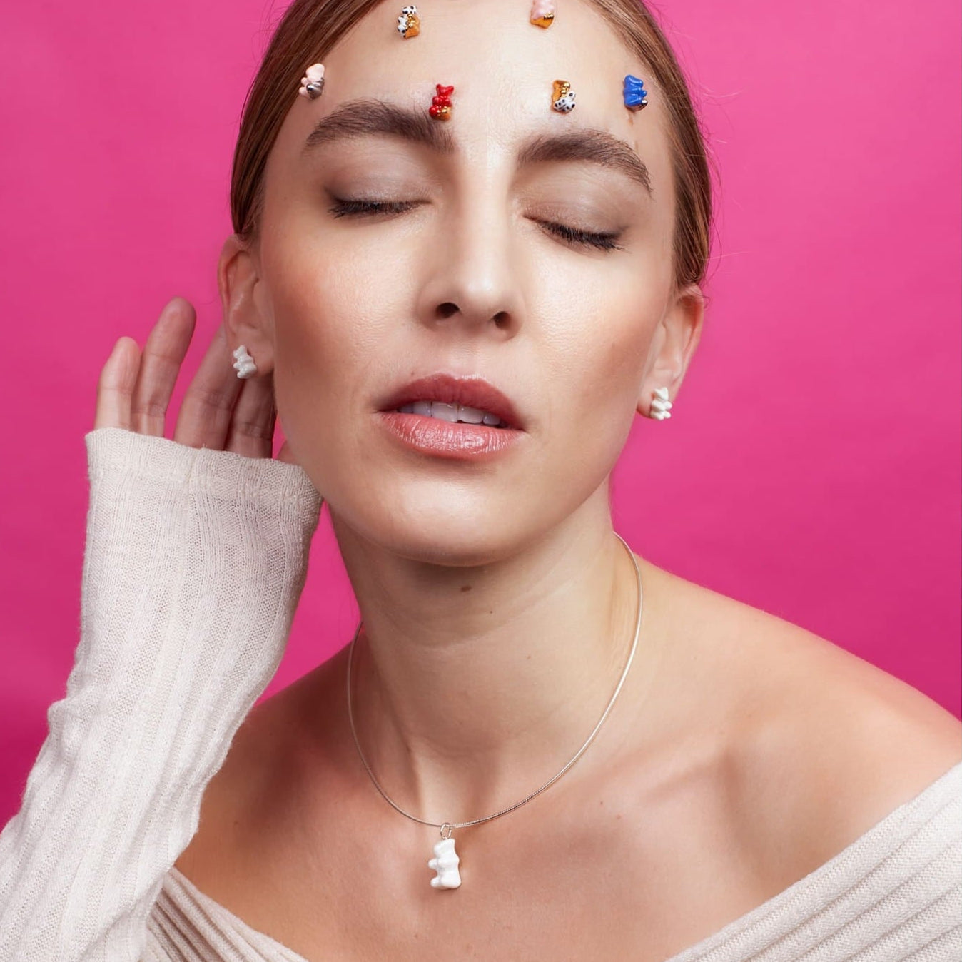 Woman wearing SILVER UP jewelry against a pink background
