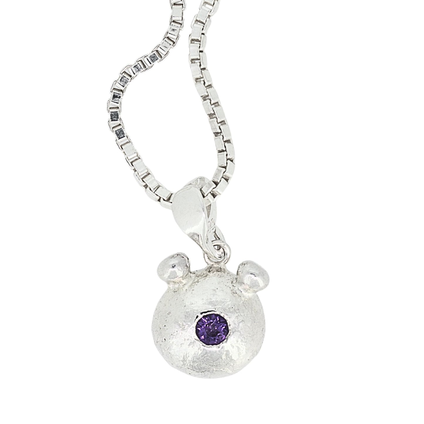 Silver bear pendant with a purple gemstone on a white background