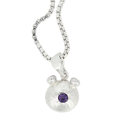 Silver bear pendant with a purple gemstone on a white background