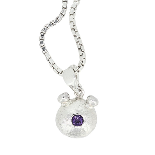 Silver bear pendant with a purple gemstone on a white background