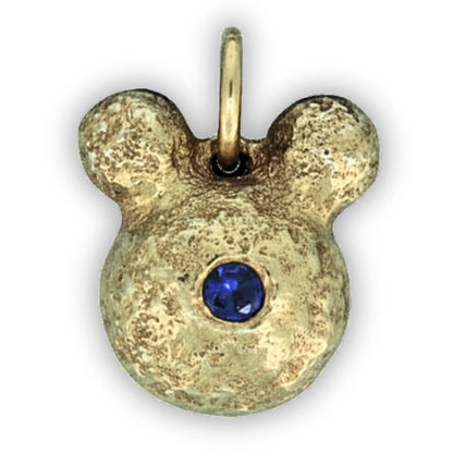 Gold pendant with a blue gemstone on a white background