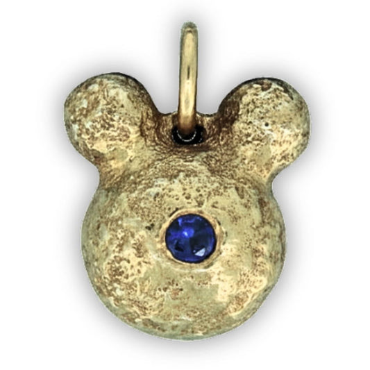 Gold pendant with a blue gemstone on a white background